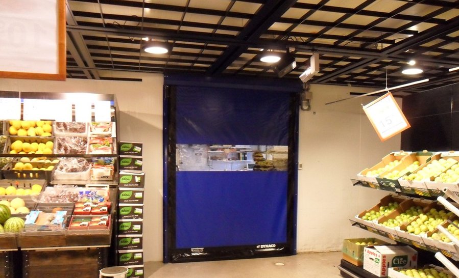 Blå rullport med siktruta mellan lager och butiksyta.